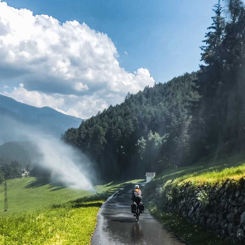 Frau fährt Fahrrad durch Regen